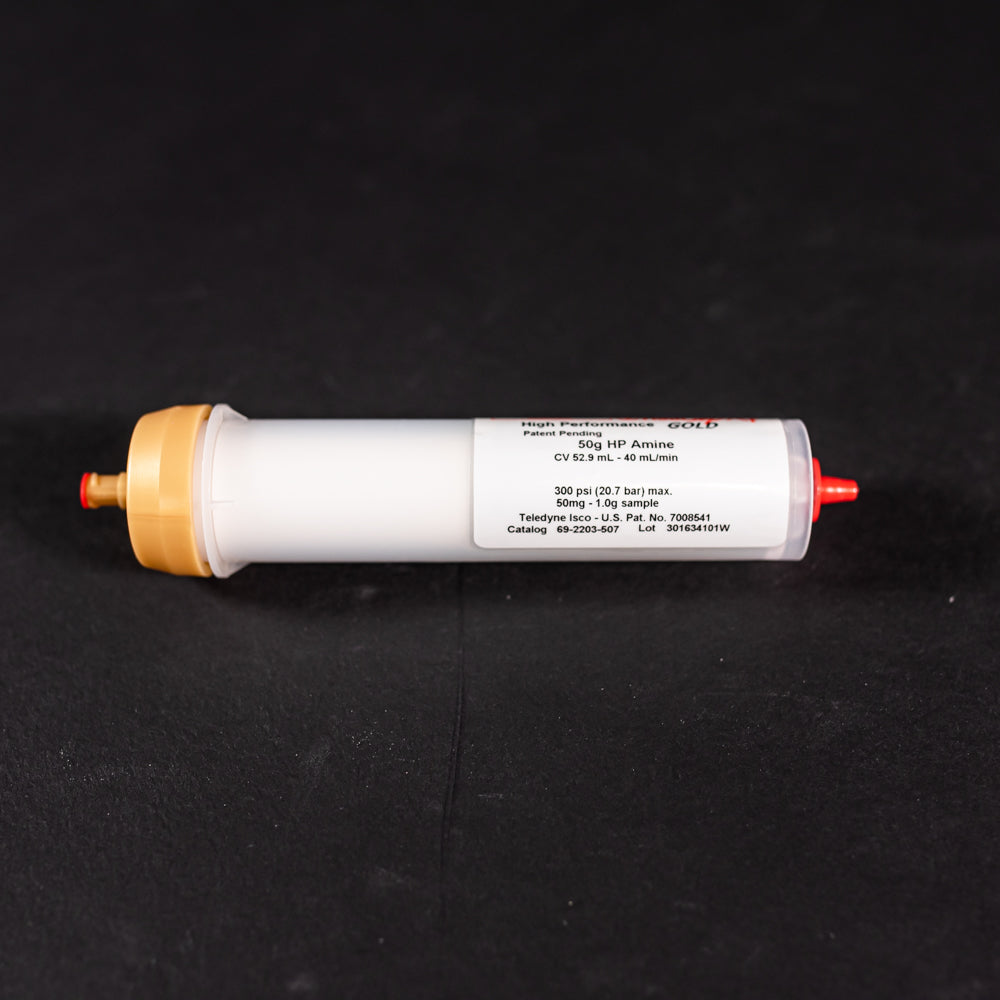 A small white tube with gold and red caps displayed on a black background, creating a striking visual contrast between the two elements.