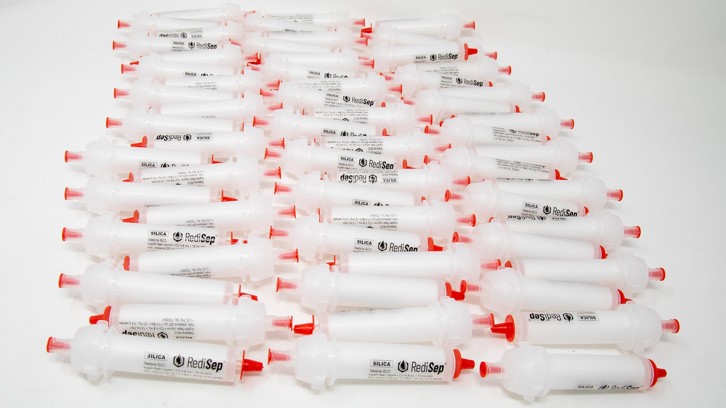 A group of plastic tubes with red caps, positioned side by side, emphasizing their contrasting colors and forms.