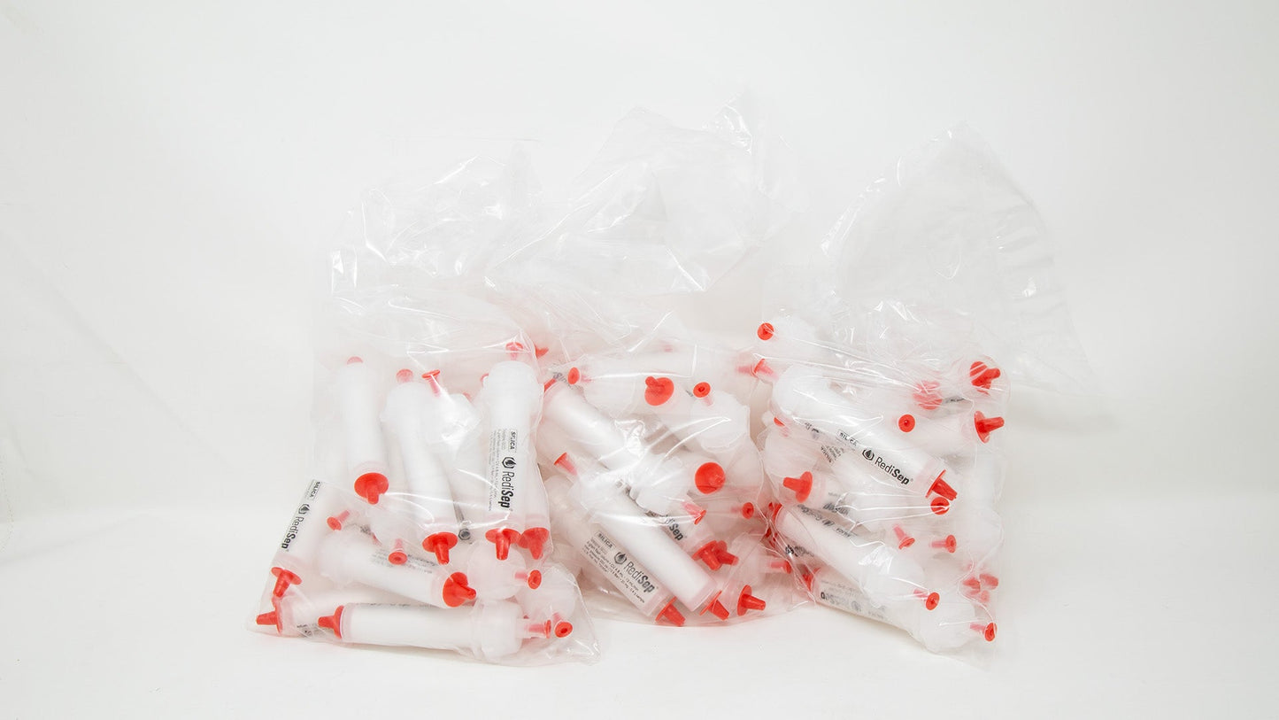 A group of plastic tubes with red caps, positioned side by side, emphasizing their contrasting colors and forms.