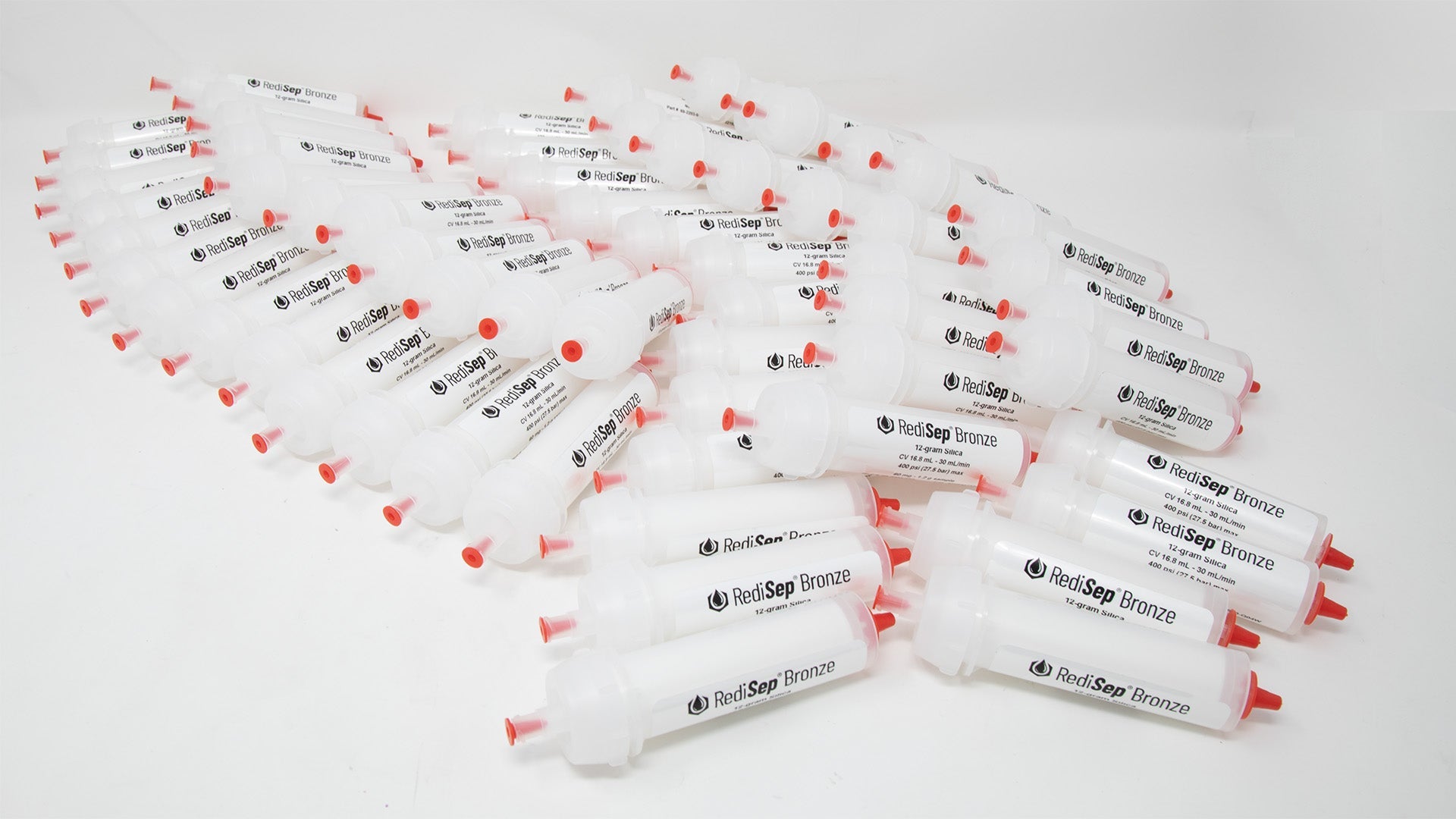 A group of plastic tubes with red caps, positioned side by side, emphasizing their contrasting colors and forms.