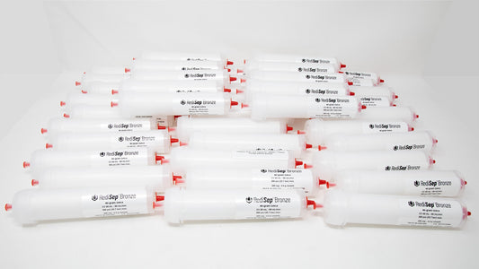 A group of plastic tubes with red caps, positioned side by side, emphasizing their contrasting colors and forms.