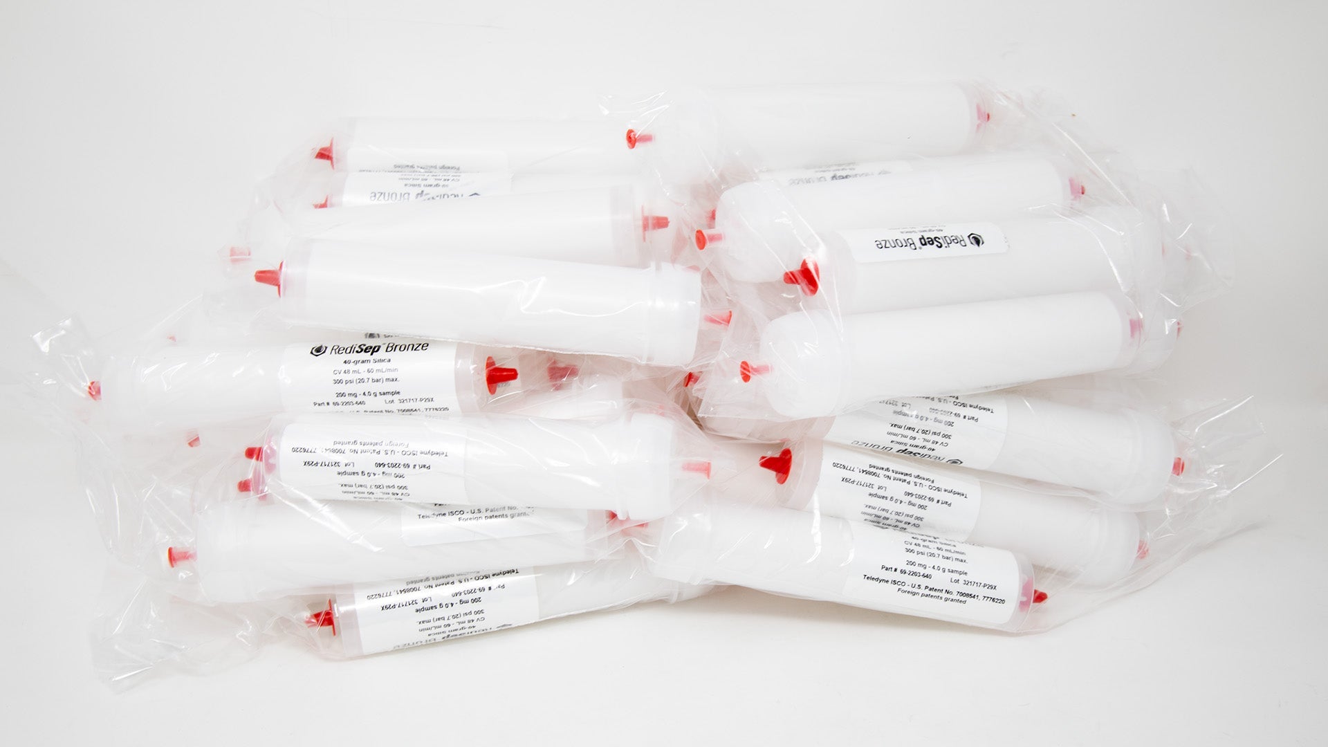 A group of plastic tubes with red caps, positioned side by side, emphasizing their contrasting colors and forms.