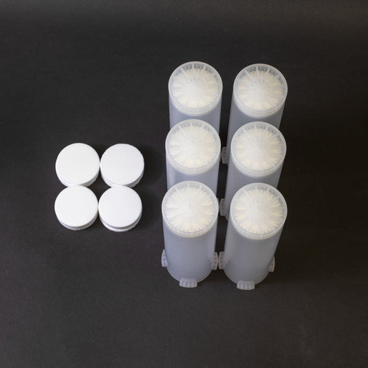 A set of small clear plastic cartridges displayed on a black background, creating a striking visual contrast between the two elements.