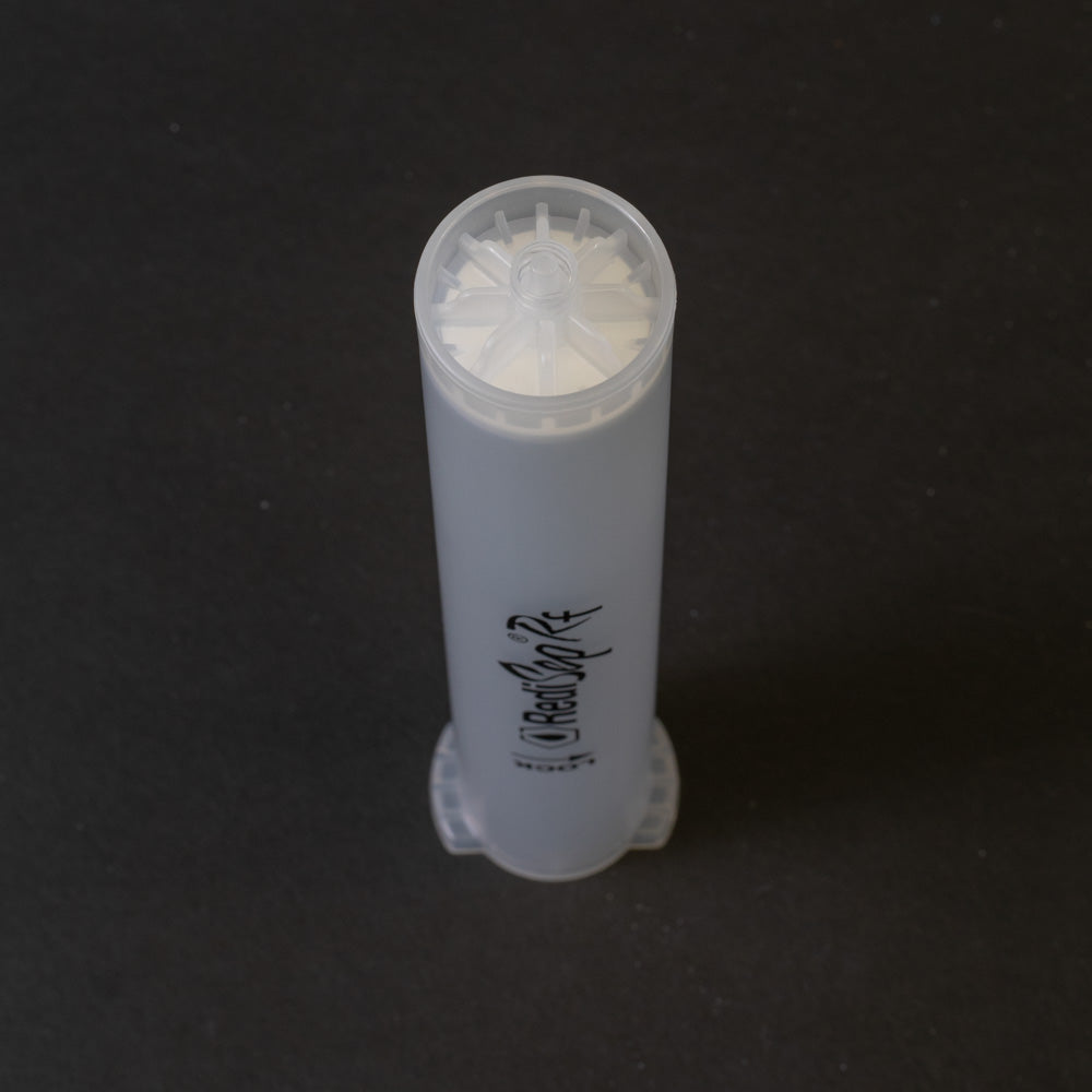 A small clear plastic cartridge displayed on a black background, creating a striking visual contrast between the two elements.