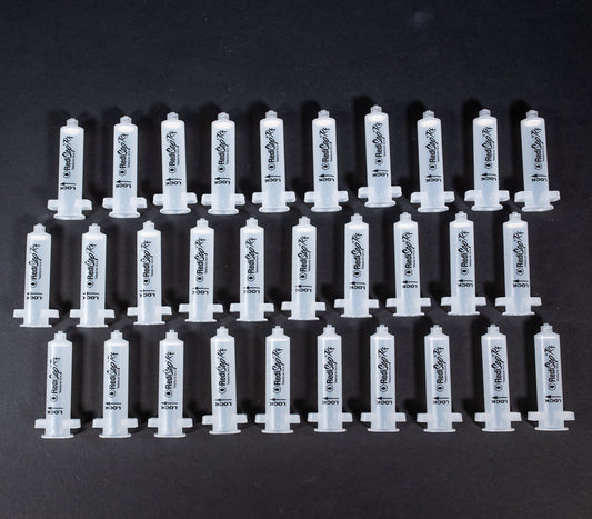 A set of small clear plastic cartridges displayed on a black background, creating a striking visual contrast between the two elements.