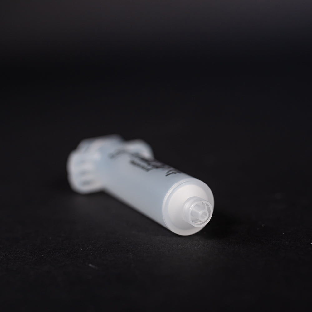 A small clear plastic cartridge displayed on a black background, creating a striking visual contrast between the two elements.