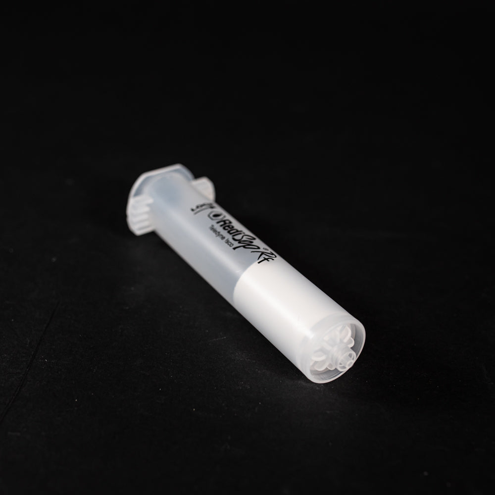A small clear plastic cartridge displayed on a black background, creating a striking visual contrast between the two elements.